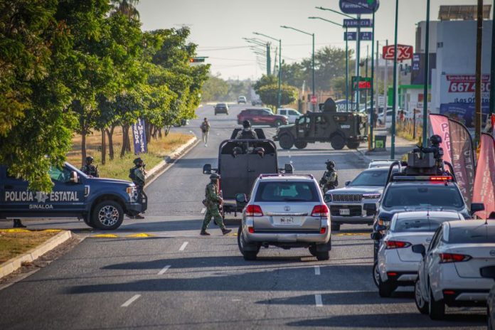 Police and security officials block the street of a crime scene in Culiacán, Sinaloa, where a federal agent was killed.