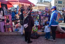 Adults and a child look at toys in an outdoor toy market in Mexico City, ahead of Kings' Day