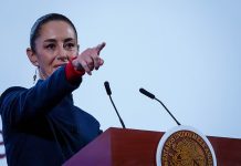 Mexican President Claudia Sheinbaum points to the crowd from her podium during her daily press conference