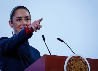 Mexican President Claudia Sheinbaum points to the crowd from her podium during her daily press conference