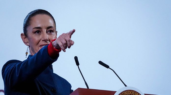 Mexican President Claudia Sheinbaum points to the crowd from her podium during her daily press conference