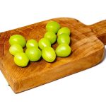 12 green grapes on a wooden serving board