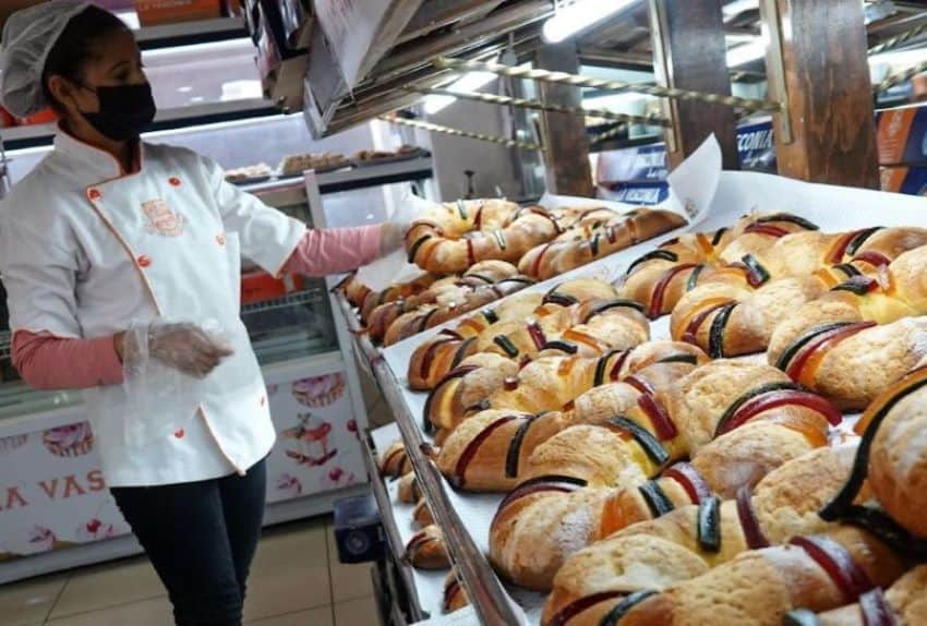 A baker displays trays full of ring-shaped king cakes decorated with strips of jewel-colored sweets, for Kings' Day in Mexico.