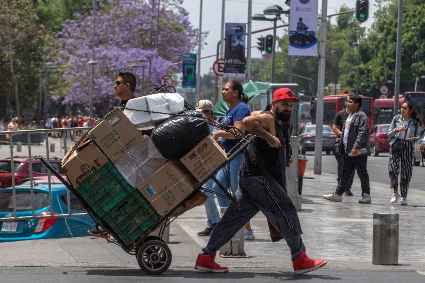 A man carrying a load of boxes on a hand truck