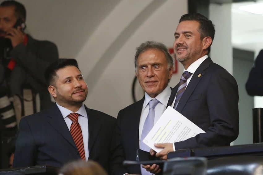 PAN Senator Miguel Yunes Márquez stands with other senators in suits and ties, holding documents