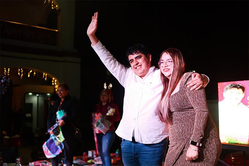 Murdered Tancanhuitz Mayor Jesús Eduardo Franco waves to a crowd at night with Christmas lights in the background