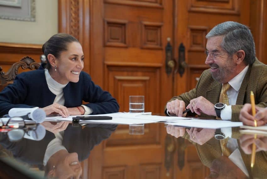 Mexico's president Claudia Sheinbaum in the national palace on a call with Donald Trump looking at Mexico's Foreign Affairs Minister Juan Ramón de la Fuente who sits aside from her at the same table.