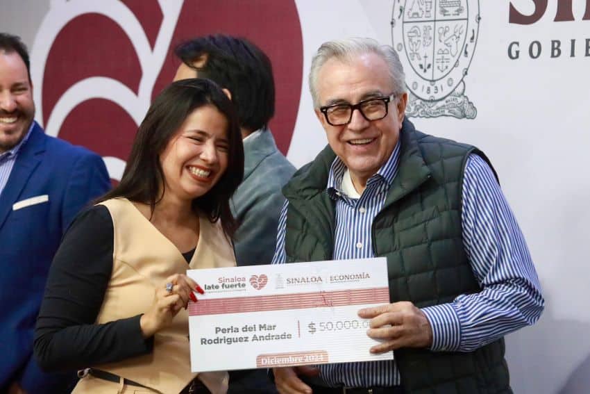 Governor Rocha Moya distributing a check from the Sinaloa Late Fuerte Program (Sinaloa Beats Strong Program) 