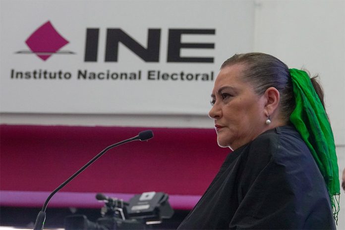 Mexico's elections chief Guadalupe Taddei stands in front of a sign reading 