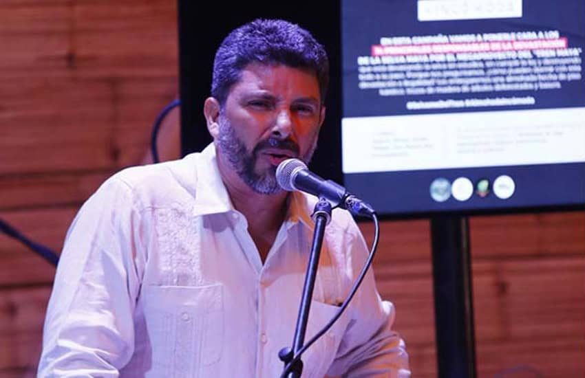 Mexican environmental activist Jose Urbina speaking at an event in front of a microphone