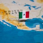 A map of Mexico with a tiny Mexican flag planted on the country