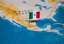 A map of Mexico with a tiny Mexican flag planted on the country